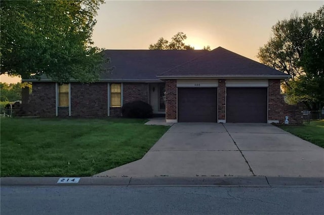 214 Johnston Pkwy, Raymore, MO 64083 - ranch-style home featuring an attached garage, a front yard, driveway, and brick siding