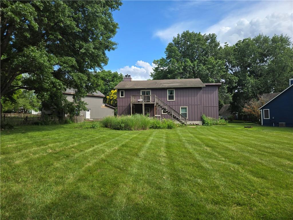 2314 W Sage Cir, Olathe, KS 66061 - back of house with stairs, a deck, a chimney, and board and batten siding