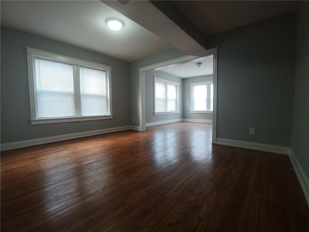 2708 Benton Blvd, Kansas City, MO 64128 - spare room featuring dark wood-style flooring and baseboards