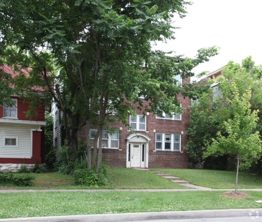 2708 Benton Blvd, Kansas City, MO 64128 - view of front of home featuring brick siding, a front yard, and a chimney