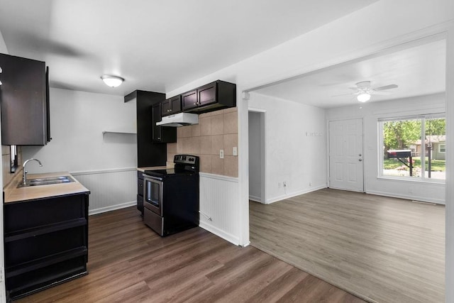 2729 S 52nd St, Kansas City, KS 66106 - kitchen with electric stove, a sink, dark wood-type flooring, light countertops, and a wainscoted wall