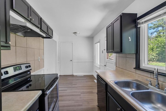 2729 S 52nd St, Kansas City, KS 66106 - kitchen with stainless steel range with electric stovetop, dishwasher, a sink, under cabinet range hood, and decorative backsplash