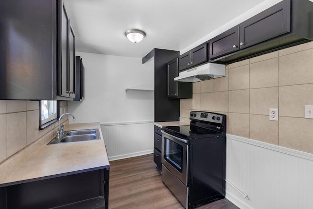 2729 S 52nd St, Kansas City, KS 66106 - kitchen featuring stainless steel range with electric cooktop, a sink, under cabinet range hood, wainscoting, and light countertops