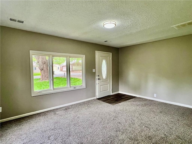 8416 Greenwood Rd, Raytown, MO 64138 - entrance foyer with dark carpet, baseboards, and a textured ceiling