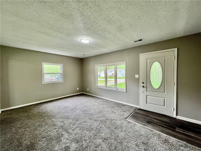 8416 Greenwood Rd, Raytown, MO 64138 - foyer featuring carpet, baseboards, and a textured ceiling