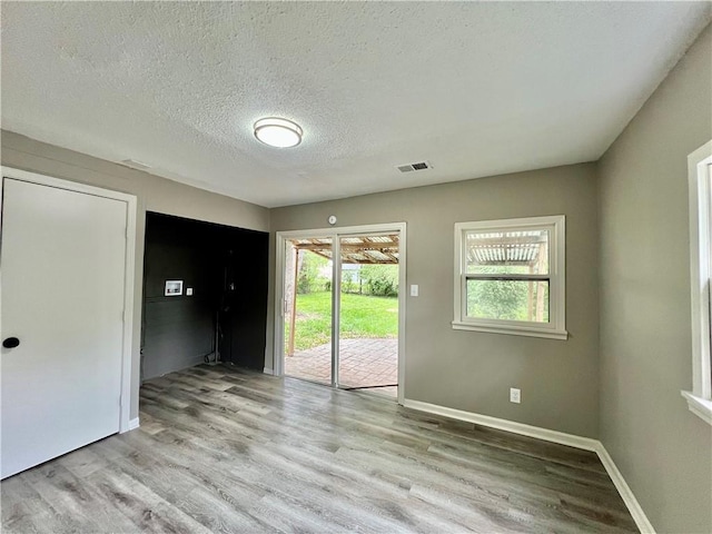 8416 Greenwood Rd, Raytown, MO 64138 - unfurnished room with light wood finished floors, a textured ceiling, and baseboards