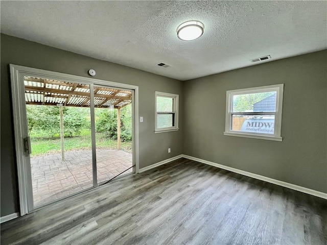 8416 Greenwood Rd, Raytown, MO 64138 - spare room with wood finished floors, baseboards, and a textured ceiling