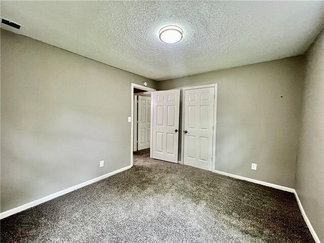 8416 Greenwood Rd, Raytown, MO 64138 - unfurnished bedroom with baseboards, carpet floors, a textured ceiling, and a closet
