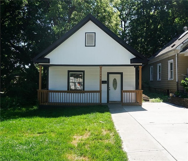 2243 Spruce Ave, Kansas City, MO 64127 - bungalow with a porch and a front yard