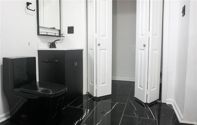 2243 Spruce Ave, Kansas City, MO 64127 - bathroom featuring baseboards, vanity, and marble finish flooring