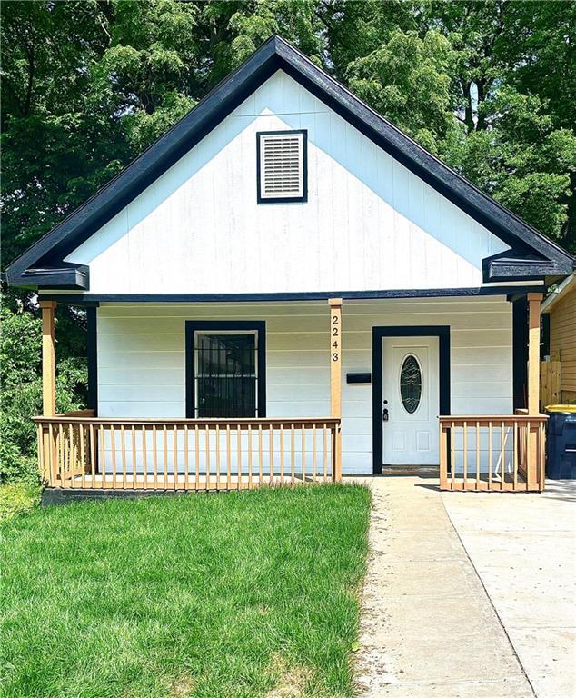 2243 Spruce Ave, Kansas City, MO 64127 - ranch-style home featuring a porch and a front lawn