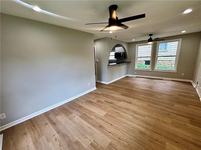 2243 Spruce Ave, Kansas City, MO 64127 - unfurnished living room with a ceiling fan, wood finished floors, baseboards, and recessed lighting