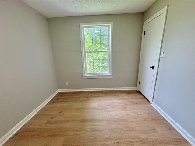 2243 Spruce Ave, Kansas City, MO 64127 - unfurnished room with light wood-style floors and baseboards