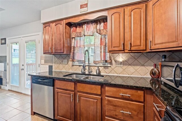 9504 E 89th St, Kansas City, MO 64138 - kitchen featuring appliances with stainless steel finishes, a sink, dark stone countertops, and brown cabinetry