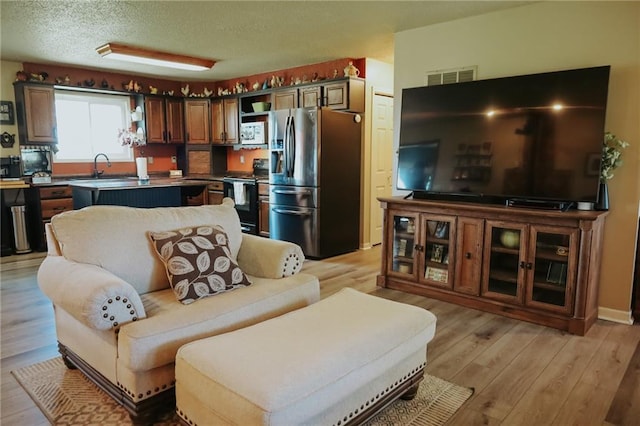 7164 State Route T Hwy, Amazonia, MO 64421 - living room featuring light wood-style floors and a textured ceiling
