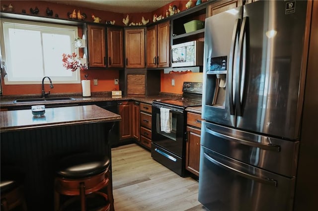 7164 State Route T Hwy, Amazonia, MO 64421 - kitchen featuring stainless steel refrigerator with ice dispenser, black range with electric cooktop, a sink, dark countertops, and light wood-type flooring