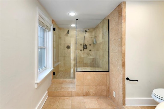 bathroom with a tile shower, toilet, tile patterned flooring, and healthy amount of natural light