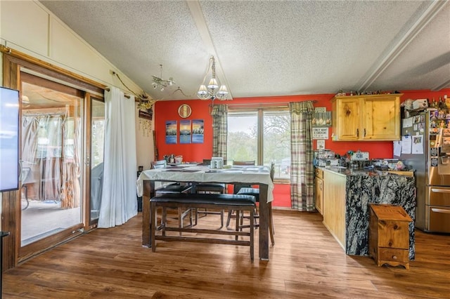 13813 Petty Rd, Kearney, MO 64060 - dining space with a textured ceiling, a chandelier, wood finished floors, and vaulted ceiling