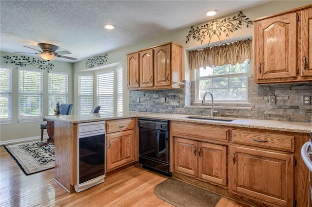 748 SW Windsong Cir, Lees Summit, MO 64082 - kitchen featuring black dishwasher, a sink, a textured ceiling, a peninsula, and ceiling fan