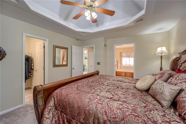 748 SW Windsong Cir, Lees Summit, MO 64082 - bedroom featuring a raised ceiling, light carpet, a spacious closet, connected bathroom, and baseboards