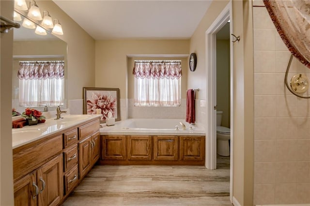 748 SW Windsong Cir, Lees Summit, MO 64082 - bathroom featuring wood finished floors, toilet, a garden tub, and double vanity