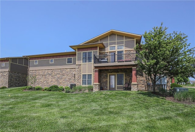 rear view of property with stone siding, a yard, and a deck
