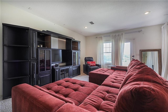 living room featuring light carpet, recessed lighting, and a textured ceiling