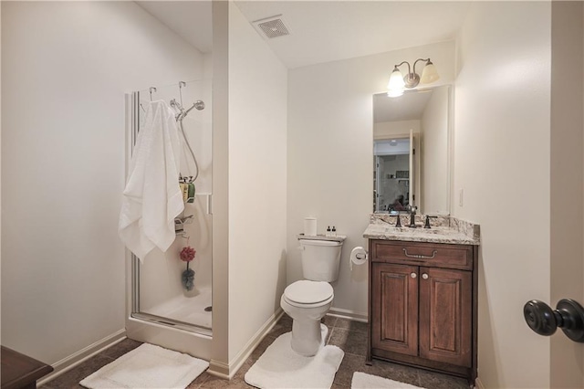 bathroom featuring a stall shower, toilet, vanity, and baseboards