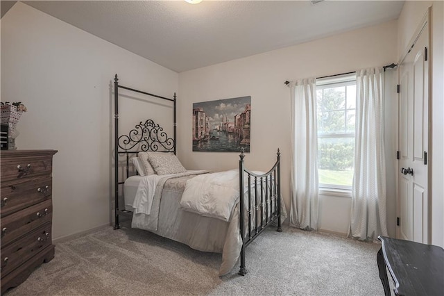 bedroom featuring light colored carpet and baseboards