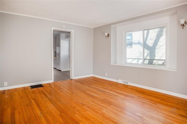 110 S Park Ave, Independence, MO 64050 - spare room featuring light wood-style flooring, ornamental molding, and baseboards