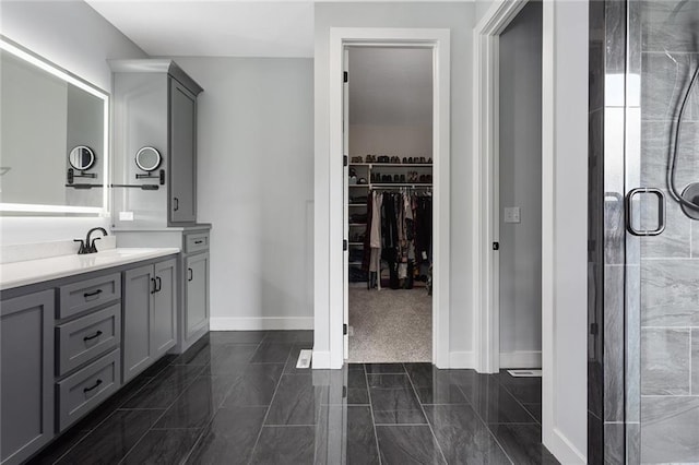 28897 Hackberry Cir, Paola, KS 66071 - bathroom with vanity, a spacious closet, baseboards, and a stall shower