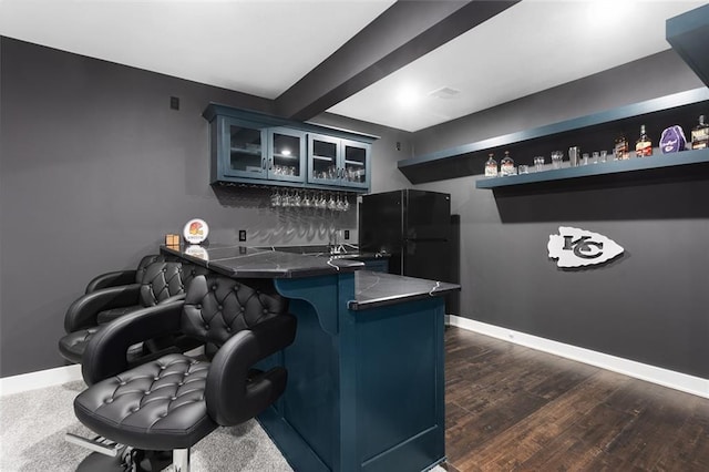 28897 Hackberry Cir, Paola, KS 66071 - indoor wet bar featuring freestanding refrigerator, baseboards, beam ceiling, and dark wood-type flooring
