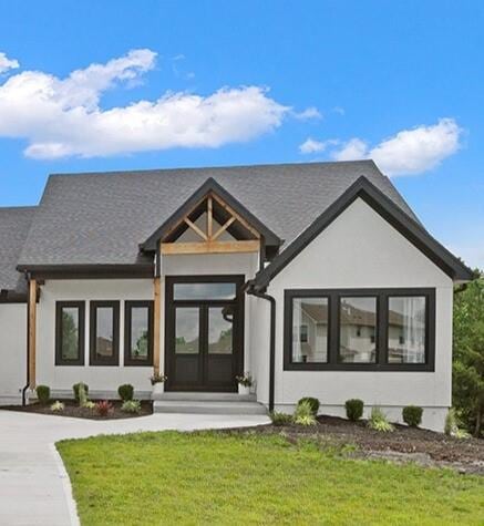 28897 Hackberry Cir, Paola, KS 66071 - view of front of home with a front yard, driveway, and roof with shingles