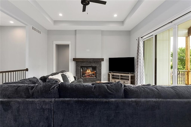 28897 Hackberry Cir, Paola, KS 66071 - living area with ceiling fan, a raised ceiling, a glass covered fireplace, and recessed lighting