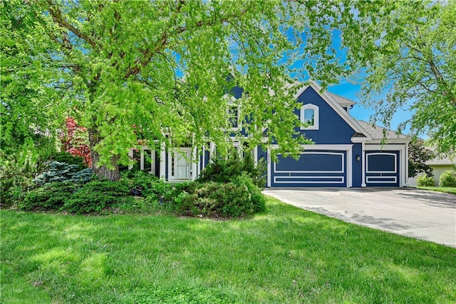 6330 N Nevada Ave, Parkville, MO 64152 - view of property hidden behind natural elements featuring concrete driveway, a front lawn, and a garage