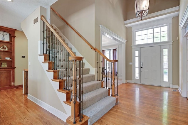 6330 N Nevada Ave, Parkville, MO 64152 - foyer entrance with a high ceiling, wood finished floors, plenty of natural light, stairway, and baseboards