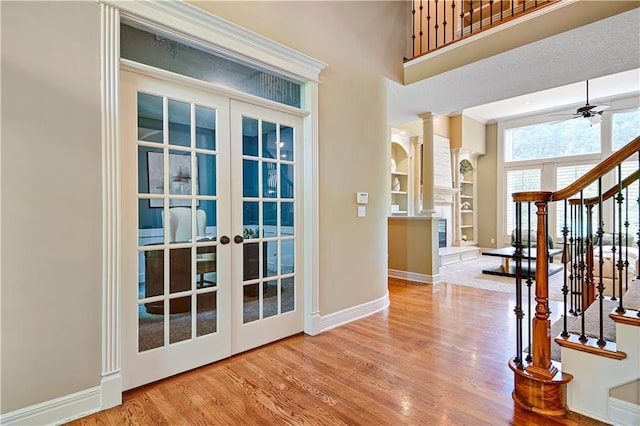 6330 N Nevada Ave, Parkville, MO 64152 - foyer with a ceiling fan, baseboards, decorative columns, wood finished floors, and stairway