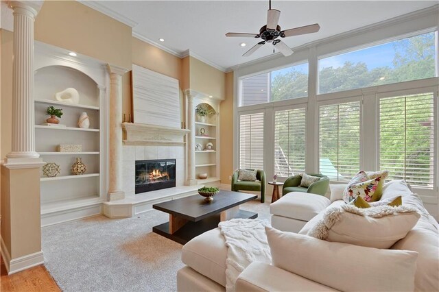 6330 N Nevada Ave, Parkville, MO 64152 - living room with crown molding, a ceiling fan, built in features, ornate columns, and a tiled fireplace