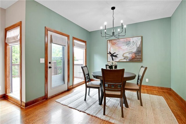 6330 N Nevada Ave, Parkville, MO 64152 - dining area with wood finished floors, a chandelier, and baseboards