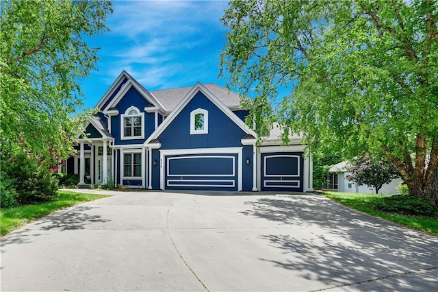 6330 N Nevada Ave, Parkville, MO 64152 - traditional home featuring concrete driveway and stucco siding