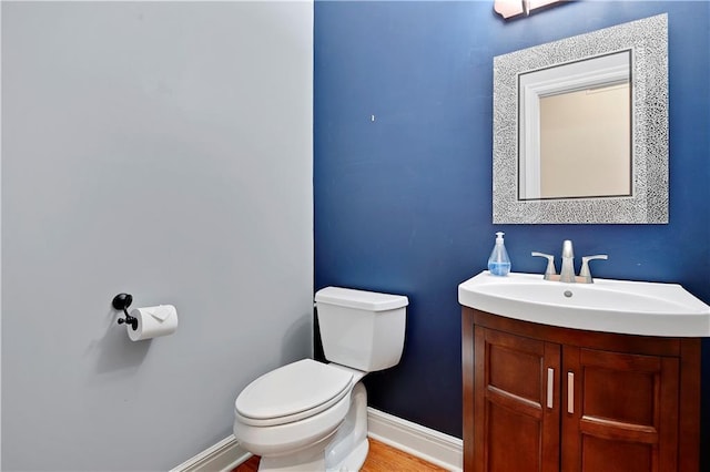 6330 N Nevada Ave, Parkville, MO 64152 - half bath with toilet, vanity, baseboards, and wood finished floors