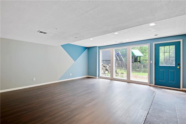 6330 N Nevada Ave, Parkville, MO 64152 - unfurnished living room featuring wood finished floors, a textured ceiling, baseboards, and recessed lighting