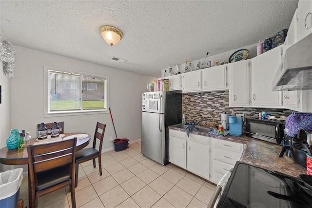 18828-30 E Wigwam Pl, Independence, MO 64056 - kitchen with freestanding refrigerator, black microwave, electric range oven, under cabinet range hood, and a textured ceiling