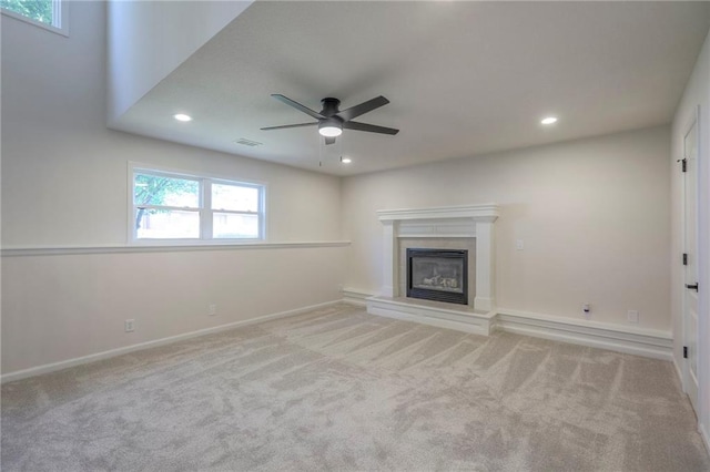 1102 Manse Dr, Raymore, MO 64083 - unfurnished living room featuring a ceiling fan, a glass covered fireplace, carpet flooring, recessed lighting, and baseboards