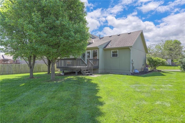 1102 Manse Dr, Raymore, MO 64083 - back of property featuring a wooden deck, a shingled roof, and central AC unit