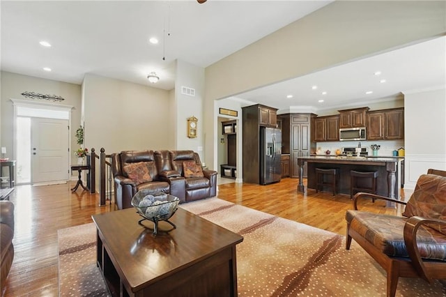 17311 Blue Moon Ln, Tonganoxie, KS 66086 - living room featuring light wood finished floors, recessed lighting, and crown molding