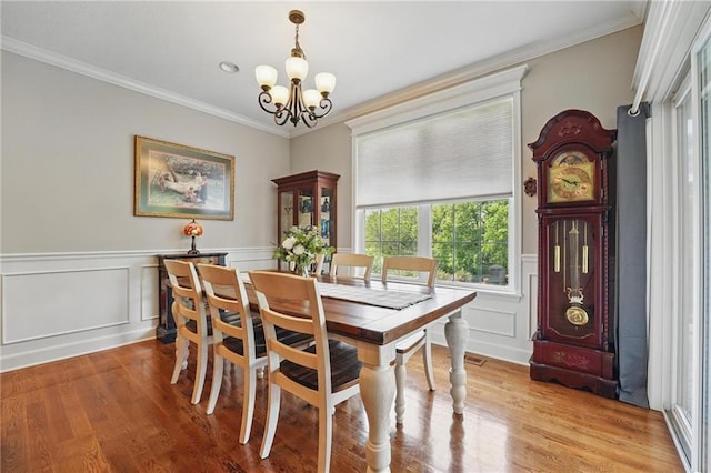 17311 Blue Moon Ln, Tonganoxie, KS 66086 - dining space featuring a chandelier, light wood finished floors, crown molding, a decorative wall, and a wainscoted wall