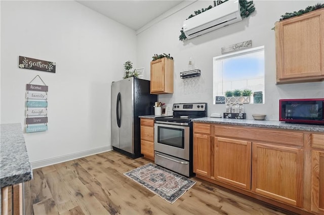 17311 Blue Moon Ln, Tonganoxie, KS 66086 - kitchen featuring stainless steel appliances, a wall mounted AC, light wood-type flooring, and light stone counters
