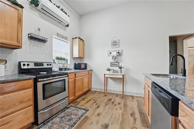 17311 Blue Moon Ln, Tonganoxie, KS 66086 - kitchen with stainless steel appliances, a sink, stone countertops, light wood-type flooring, and baseboards
