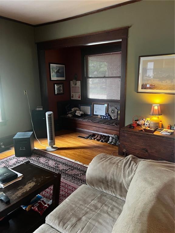 315 W 4th St, Ottawa, KS 66067 - living room featuring wood finished floors and crown molding